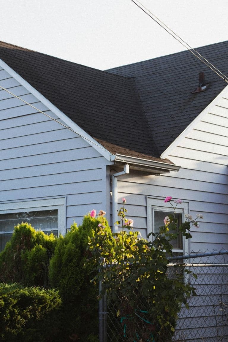 A white house with black shingle roofing.