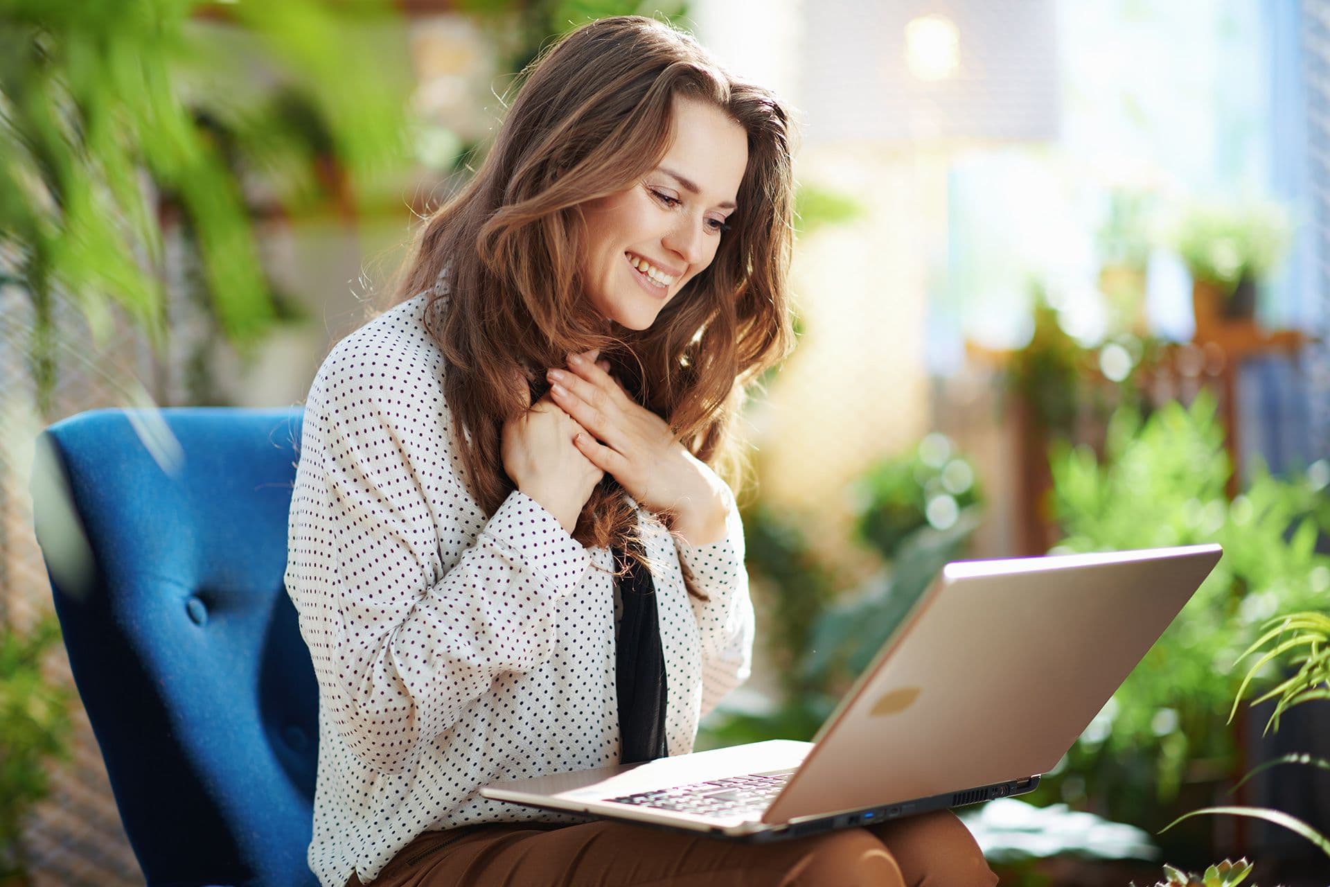 Woman sitting at laptop very happy