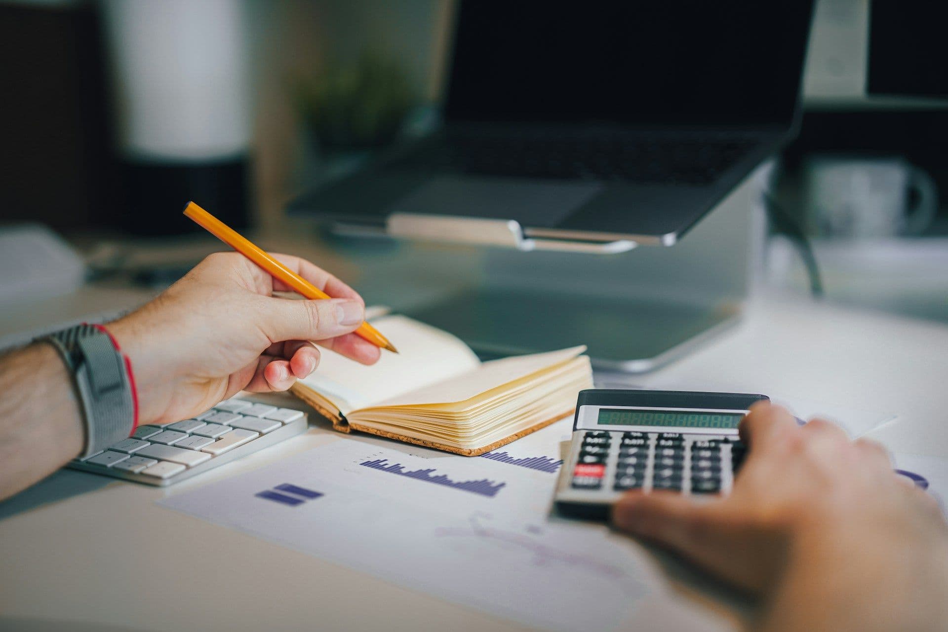 A person uses a calculator at a desk.
